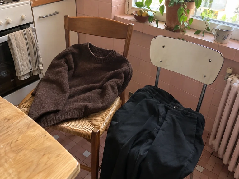 Un pull chocolat et un pantalon noir sont comparés à la lumière du jour