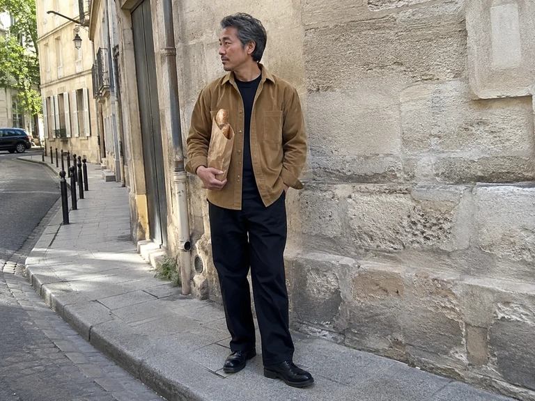 Un homme porte une veste caramel avec un pantalon noir