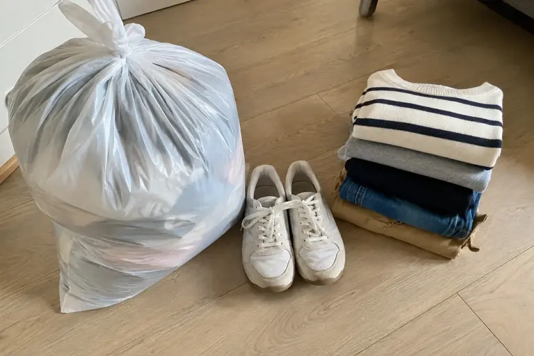 Un sac fermé et une paire de chaussures liée sont préparés avec des vêtements propres