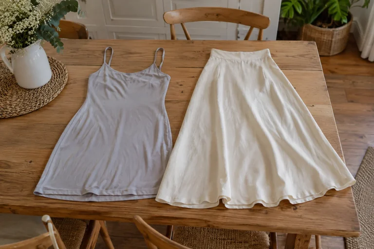 A gray slip and a light skirt laid out separately