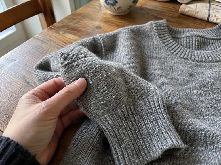Des bouloches sont visibles sur une maille grise