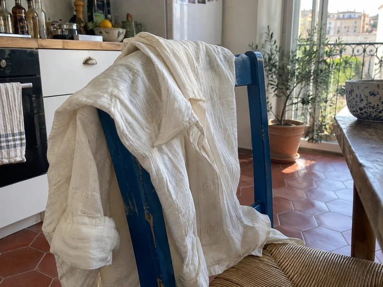 La texture irrégulière d’une chemise en lin posée sur une chaise