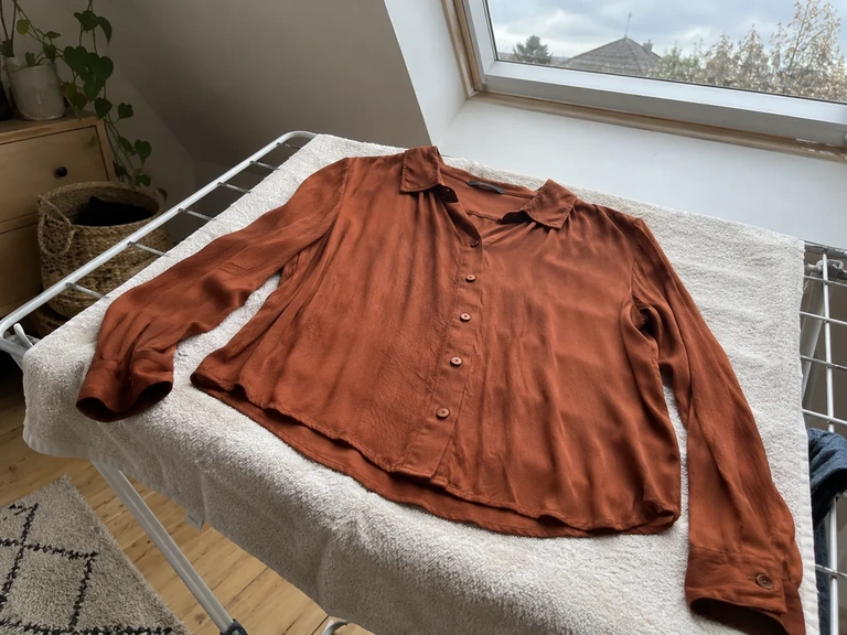 Une blouse en viscose est remise en forme sur une serviette