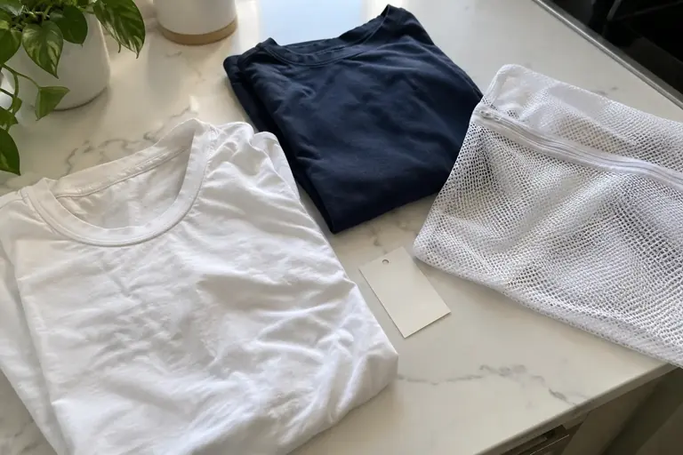 Des vêtements neufs sont séparés sur un plan de travail avec un filet de lavage