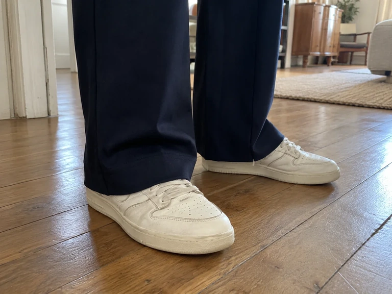 Un ourlet de pantalon large reste au-dessus du sol avec des baskets