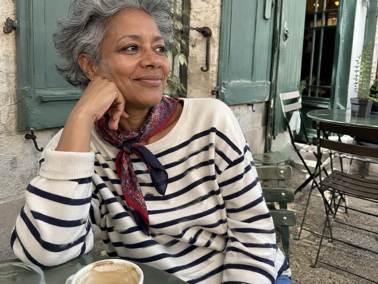 Une femme porte un foulard imprimé avec une marinière