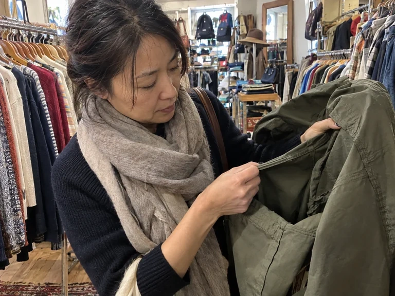 Une femme examine la couture d’une veste en boutique