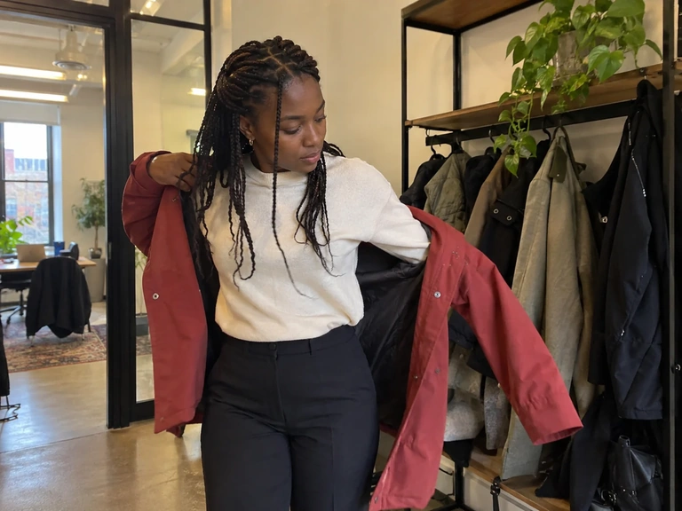 Une femme retire sa veste dans un petit vestiaire