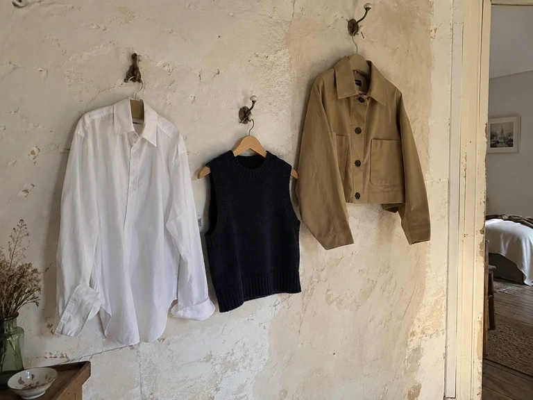 Trois couches de vêtements montrent leurs longueurs sur des cintres