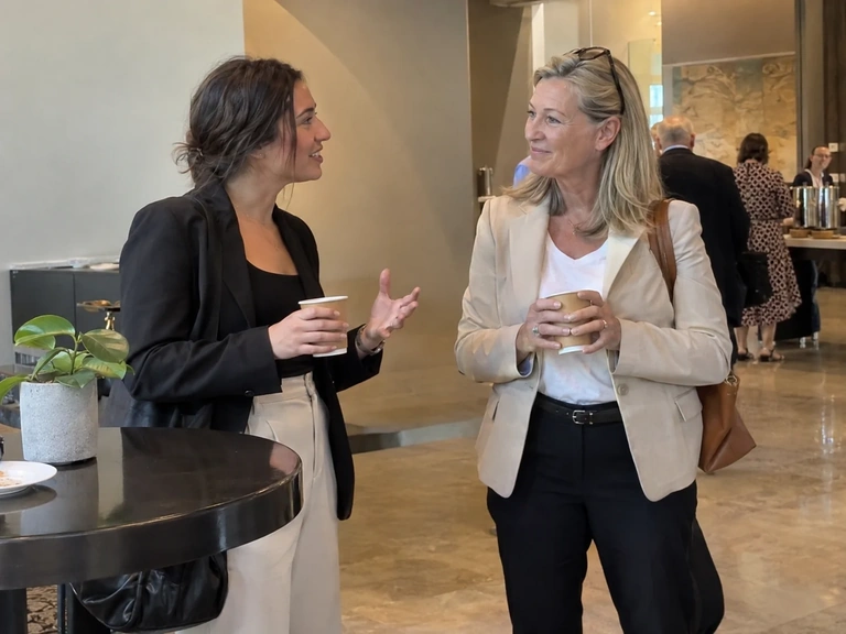Deux participantes discutent pendant une pause de conférence
