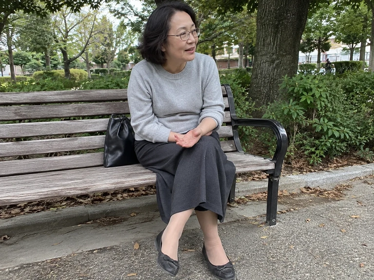 Une femme porte un ensemble gris avec des chaussures sombres