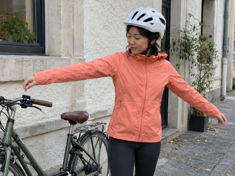 Une cycliste teste les manches de sa veste près d’un vélo stationné