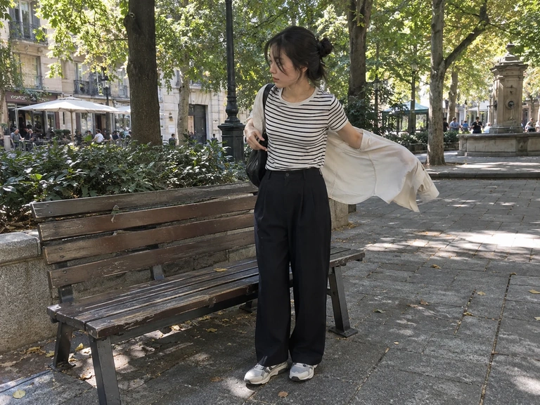 Une femme retire sa surchemise pendant une pause sur une place