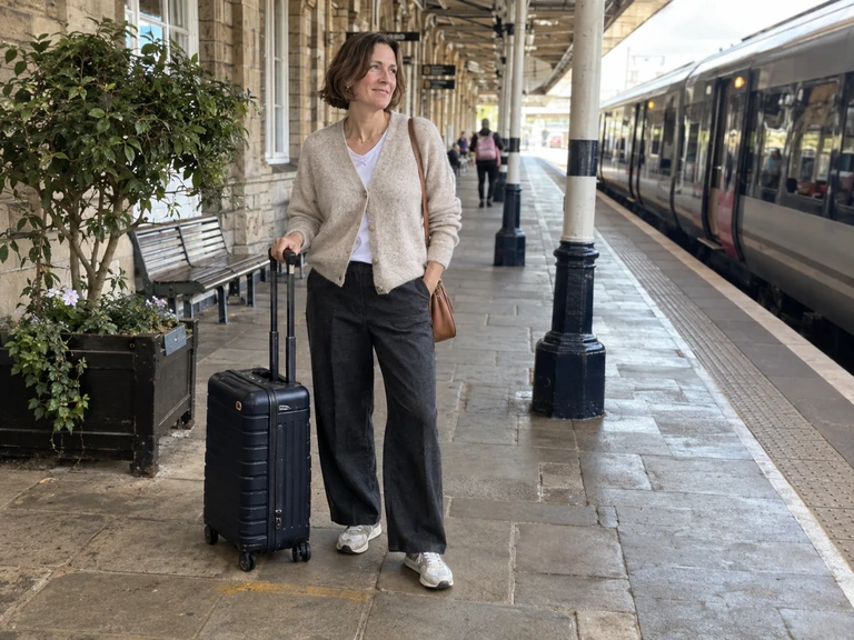Une voyageuse en tenue souple attend sur un quai de gare