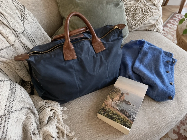 Un cardigan et un livre restent près d’un petit sac avant le départ